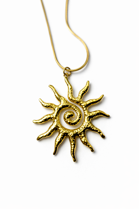 Gold sun-shaped pendant on a white background by Zenva