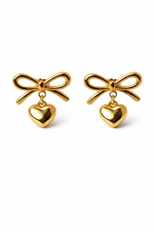 Gold bow-shaped earrings with heart pendants on a white background by Zenva