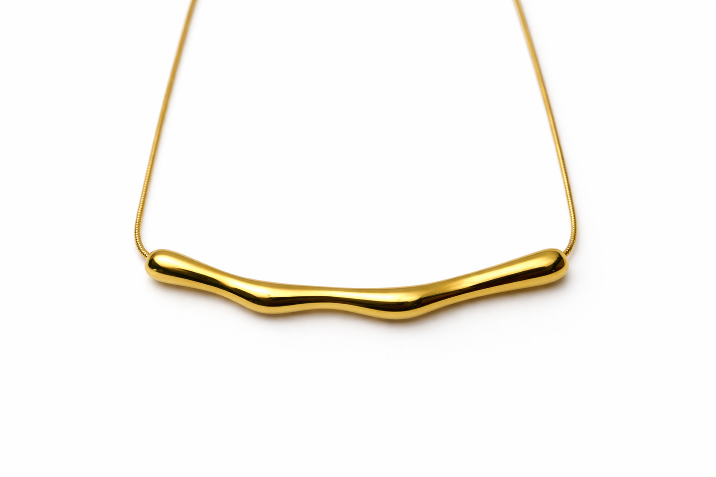 Gold necklace with a wavy design on a white background by Zenva
